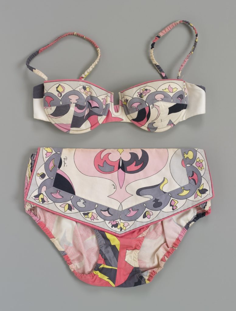 A bikini of multi-coloured patterned cotton fabric finished in pink, grey, black, white and yellow. The top has moulded cups and button fastening. The pants have elastic sides with an additional modesty panel flap attached over front.